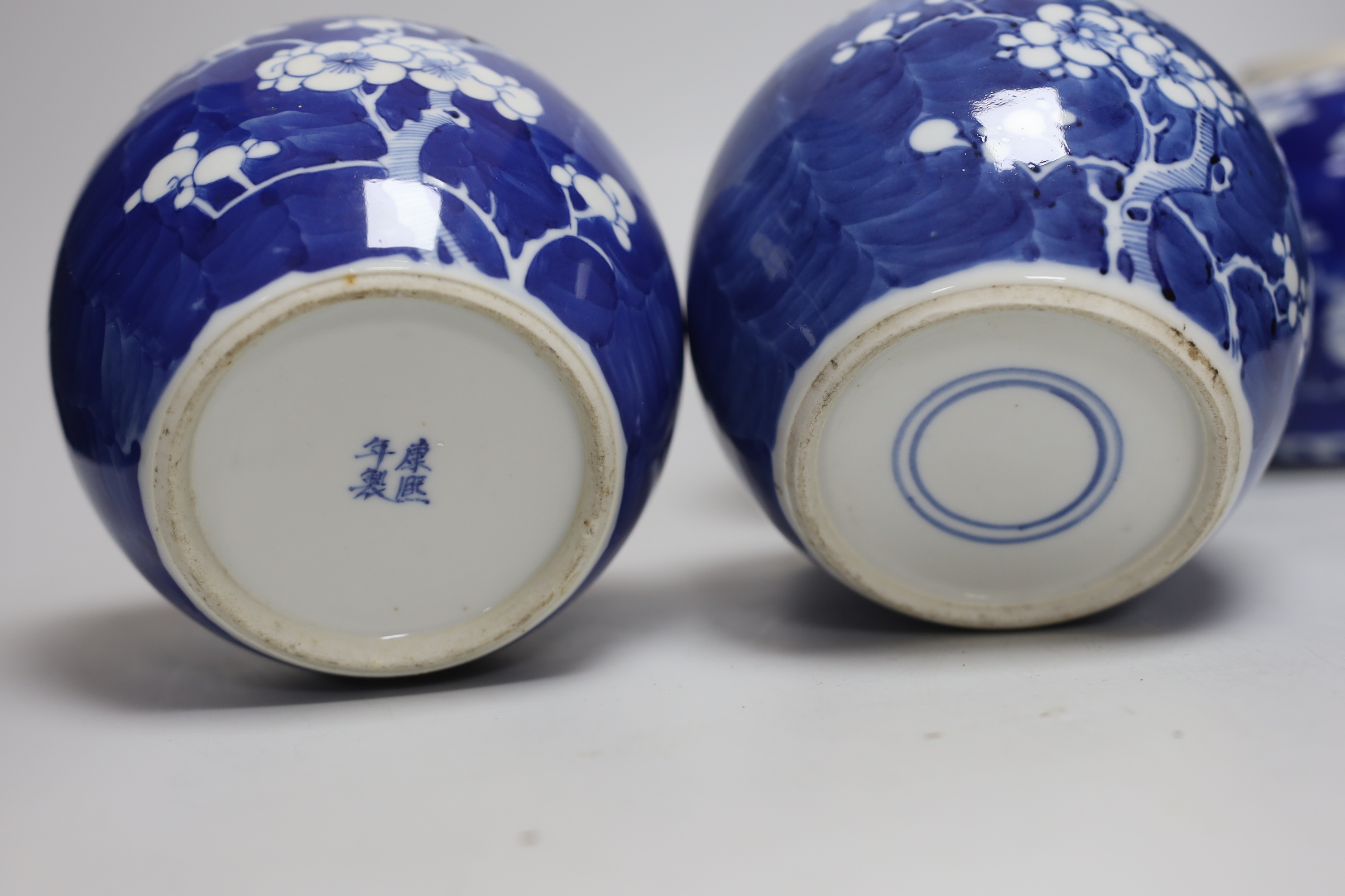 Five Chinese blue and white prunus ginger jars, one with cover- 15cm high and another jar